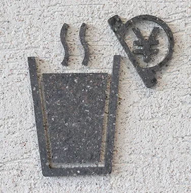 A photograph of a table and facility signs made from waste plastic generated during the manufacturing process.